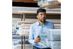 Image Man in factory with papers.